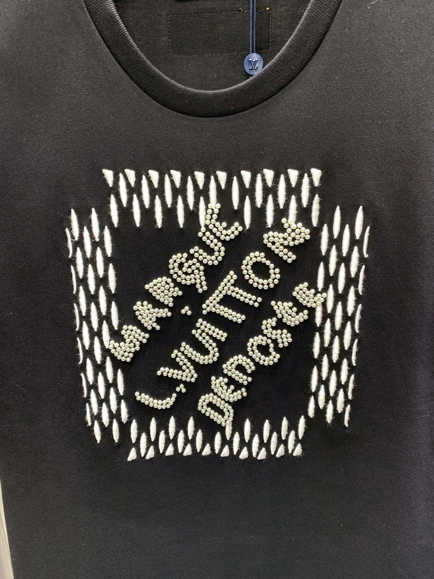 🅿️280 🀄️ Louis Vuitton Louis Vuitton 1V Louis Vuitton 2025FW The most expensive embroidered/pearl beaded half-sleeved T-shirt in history. This cotton T-shirt is from the 2025 spring and summer show. It shows the latest designer Pharrell Williams/Fei Dong's Marque L. Vuitton déposée logo created by citing the brand archives. Beaded embroidery and delicate silk threads highlight the dandy theme of the season. The reverse-effect beaded embroidered label injects a trendy look into the casual look. The fabric is made of 40s double-ply combed cotton + long-staple cotton blended compact siro-spun yarn. The weight is 280g. The front panel is embroidered with Tajima embroidery machine imported from Japan. Thick rubber pad base polyester mercerized three-dimensional hemming embroidery. Each bead is hand-pointed. A cardboard mold is opened. A single cut piece is powder-swept for precise positioning. The beads are made with 4-mile round pearlescent white bubble beads and are hand-crocheted. All single beads are tied with hooks and threads to ensure they are in the right position to sweep the powder, which is different from the ordinary beaded versions on the market.
